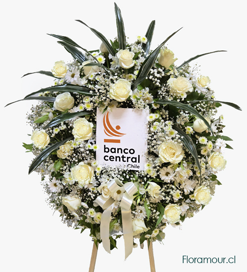 Ofrenda corona corporativa importante montada en trípode, confeccionada con rosas blancas y flores mixtas de complemento. (EL LOGO DE SU EMPRESA DEBE SER ENVIADO POR MAIL UNA VEZ QUE CULMINE SU PEDIDO:  adm.floramour@gmail.com.  +569987054409)